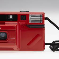 Red plastic camera with black cord strap.