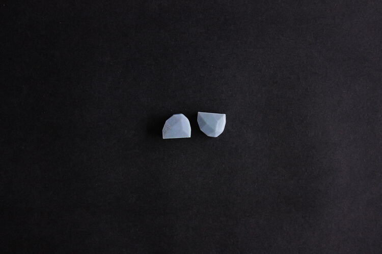 Two light blue plastic, hemispherical, facetted devices.