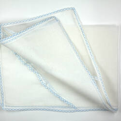 Folded piece of sheer white fabric with blue trim.