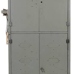 Front view of grey metal cabinet with four quarter-sized closed doors.