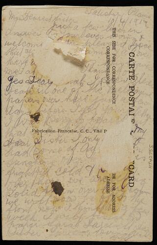 Damaged and torn postcard with handwritten text.