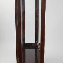 Wooden framed crystal cabinet. Glass doors and sides mirror at back. Side view, doors closed.
