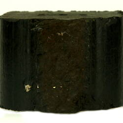 Side view of black briquette.