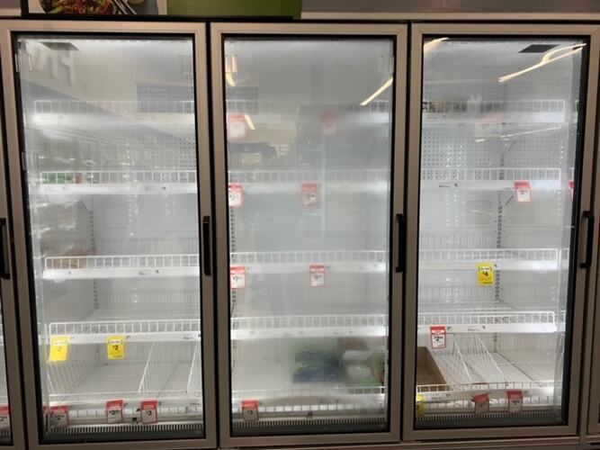 Empty supermarket freezer with glass doors.