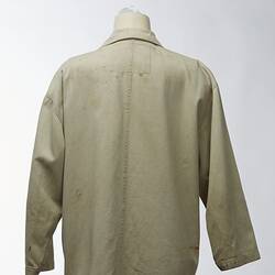 Large beige coat with elasticised pockets. Back view.