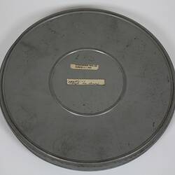 Round metal film canister. Two labels with text.