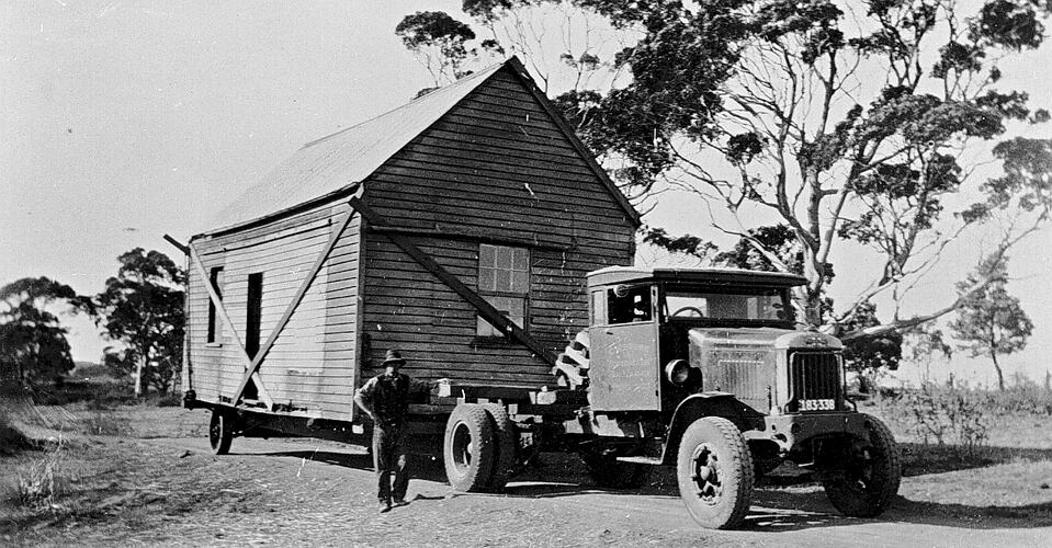 [A house being moved by a truck, Scotsburn, about 1930.]