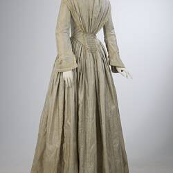 Pale grey striped silk dress with long sleeves and long skirt.