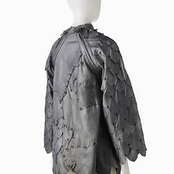 Back of short shift-style dress made from irregular pieces of pewter grey leather to resemble reptilian scales.