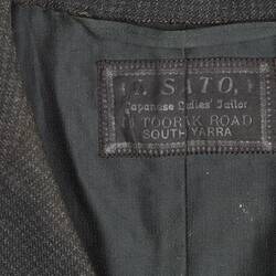 Detail of label in black and grey checked jacket. Darak lining and label.