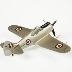 Model aeroplane, silver with a black propeller and wheels.