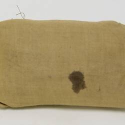 Plain back of bandage package with bandage inside.