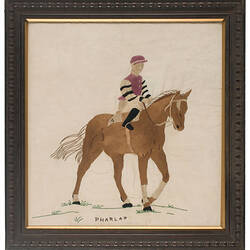 Framed embroidery of race horse.