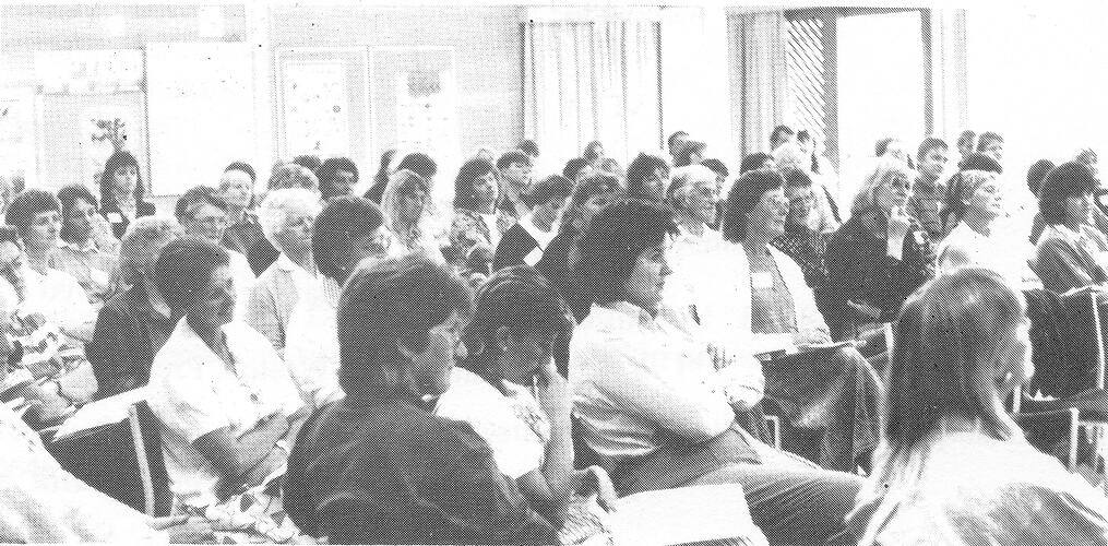 Black and white view of seated crowd.