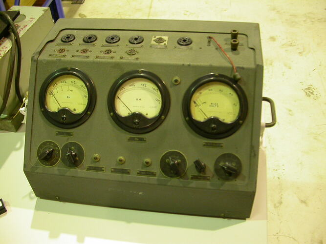 Grey metal box with dials, switches and lights.