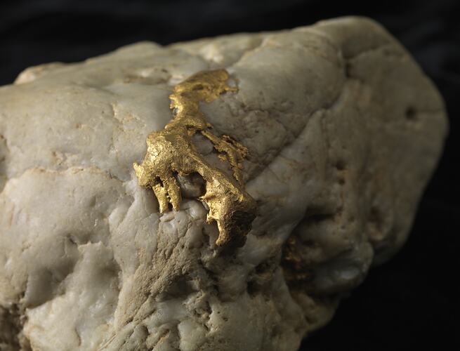 Gold on surface of white rock.