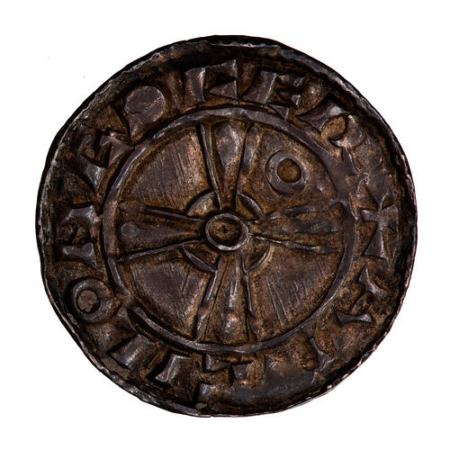 Coin, round, Short cross voided with limbs expanding with an annulet in the fourth quadrant; text around.
