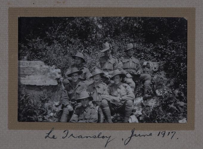 Group of servicemen sitting on a hillside.
