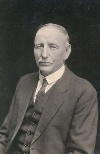 Head and shoulders portrait of man in suit.