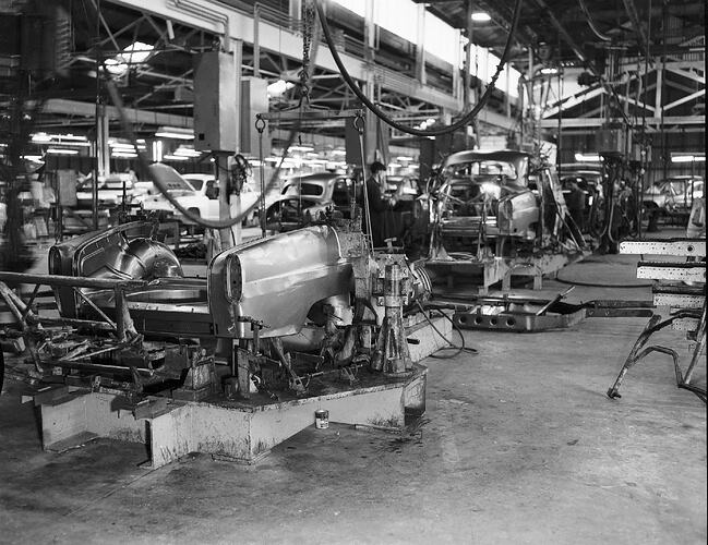 Monochrome photograph of a vehicle manufacturing plant.