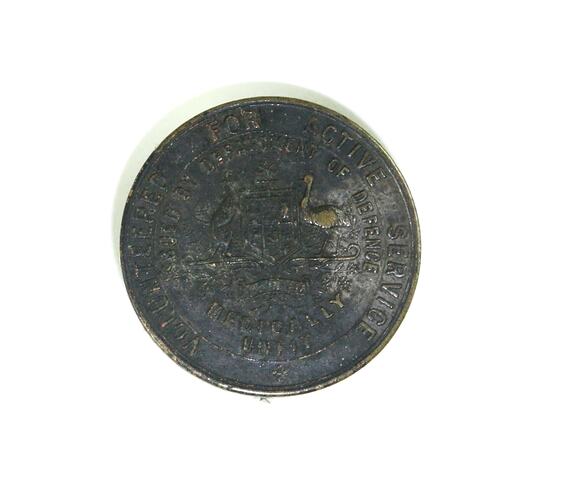 Front of circular badge with inscriptions.