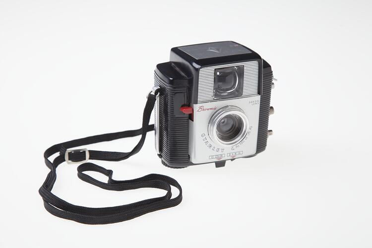 Black plastic camera with black neck strap.