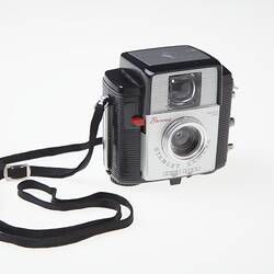 Black plastic camera with black neck strap.