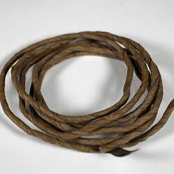 Coil of brown string made of paper.