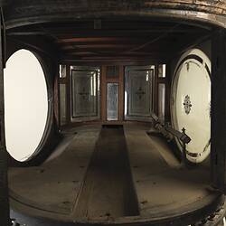 Black wooden hearse, internal view. Decorative oval glass paned cabin.