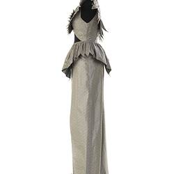 Silver grey sleeveless evening dress. Ruffles at waist, neckline, shoulders. Profile.