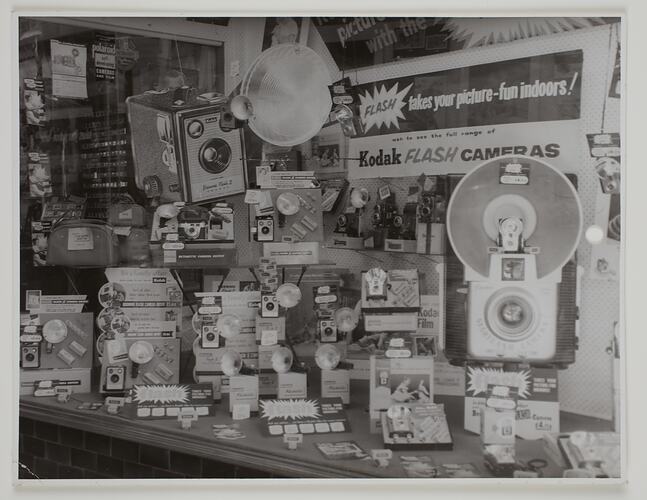 Shopfront display of cameras and flash accessories.