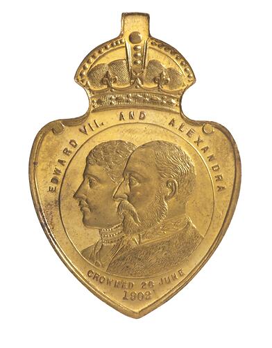 Shield shaped medal with crown atop featuring conjoined busts of Edward VII and Queen Alexandra, facing left.