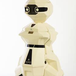 Cream plastic robot with angular human-like shape, ie. head, shoulders, waist and legs. Black plastic features.