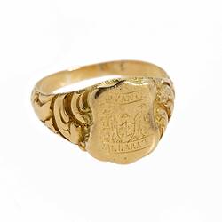 Gold ring with engraved shield design. Features Coat of Arms.