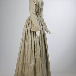 Pale grey striped silk dress with long sleeves and long skirt.