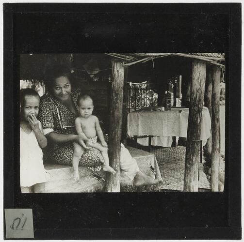 Woman and two children in a hut.