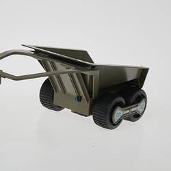 Plastic grey toy trailer with two wheels. Left front three-quarter view.