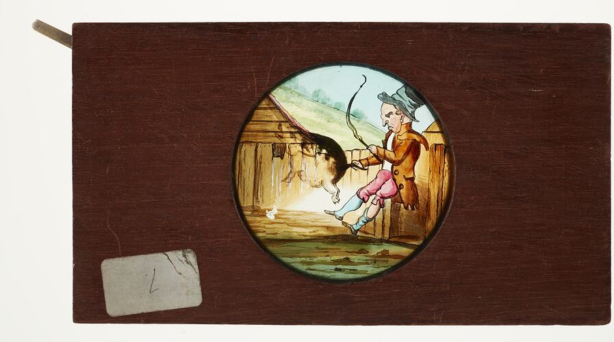 cartoon illustration features a man holding a pig by the tail with one hand and holding a whip in the other. When the lever is moved, the pig jumps in the air.