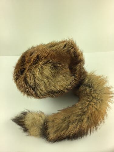 Grey furry cap with racoon like tail.