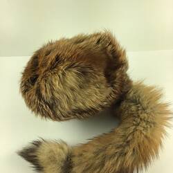 Grey furry cap with racoon like tail.