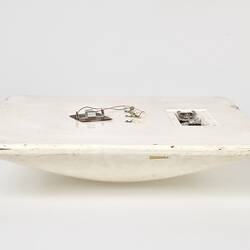 Scuffed white plastic square plate with curved base and rounded corners. Profile.