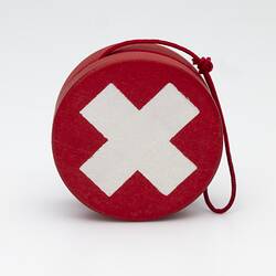 Red yo-yo with white cross. Red string.
