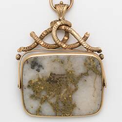 Rectangular pendant featuring white gold-bearing quartz in a gold setting, complimented by a delicate branch-like motif at the top.