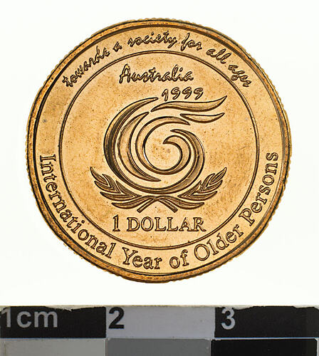 Round brass coin with central swirled lines and text around.
