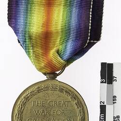 Round medal with text and rainbow ribbon.