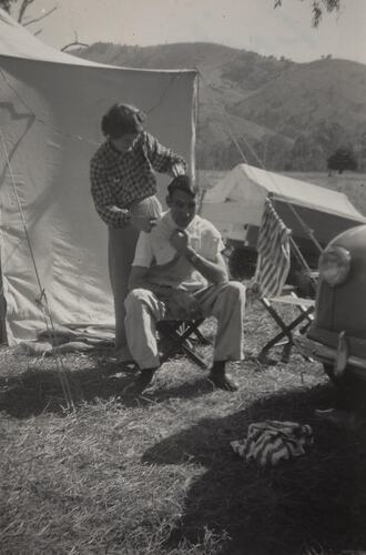 Digital Photograph - Woman Cutting Man's Hair While Camping, McAlister River, Licola, 1951