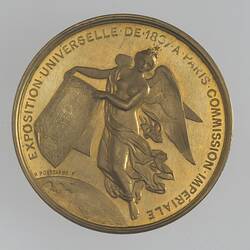 Medal with winged woman holding map, text around.