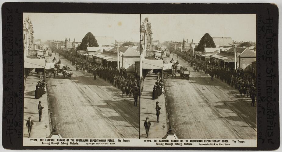 Procession of soldiers marching along one side of dirt road with carriages on other side.