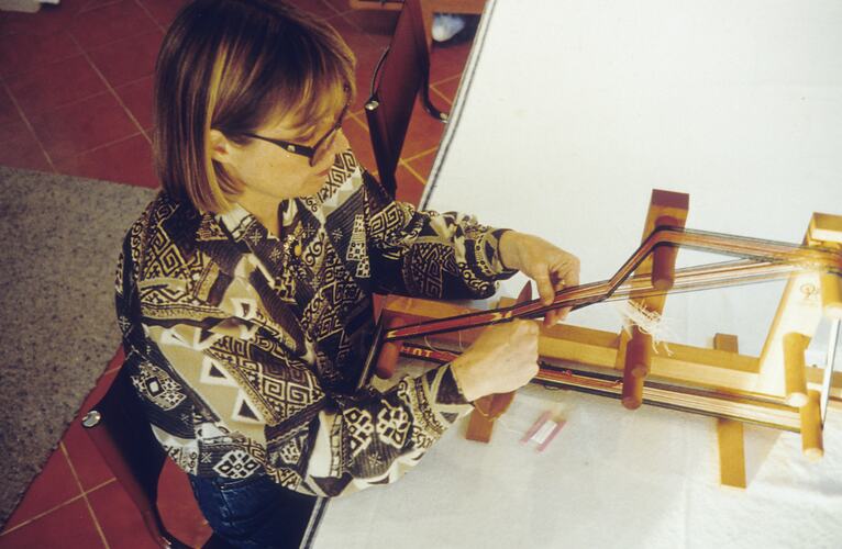 Slide - Anita Apinis-Herman demonstrating Inkle Loom Weaving, circa 1985