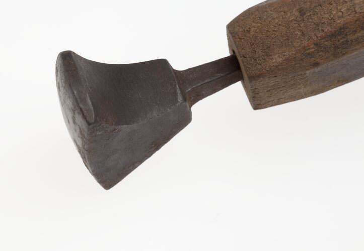 Left view iron tool mounted onto wooden handle.